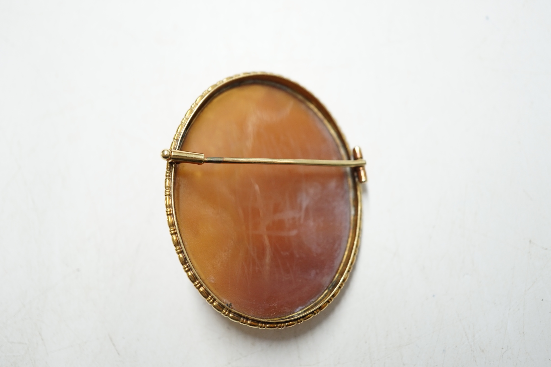 A continental yellow metal mounted oval cameo shell brooch, carved with fairies, 47mm, gross weight 11.6 grams. Condition - fair